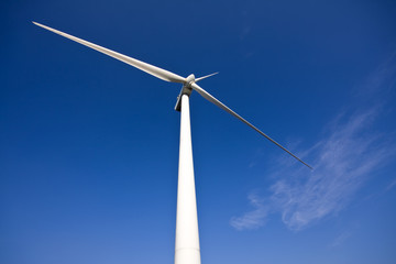 white wind turbine generating electricity on blue sky