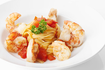 Garnelen mit Tomaten auf einem Tagliatelle-Nest