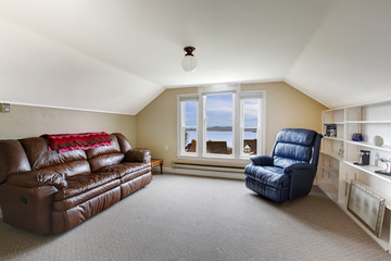 Top floor family room with brown leather sofa and blue chair