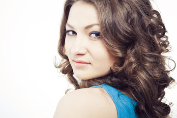 Naklejka premium Face of a beautiful young woman with brown long ringlets hairs