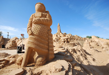sand sculpture of astronaut with american flag