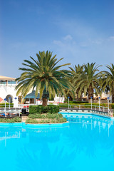 Fototapeta na wymiar Swimming pool and palm trees at the luxury hotel, Crete, Greece