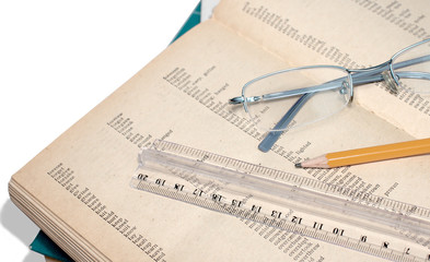 An old book, ruler, eye glasses, pencil