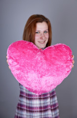 Red-haired girl with heart toy.