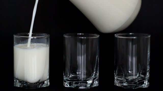Glasses of milk on a dark background