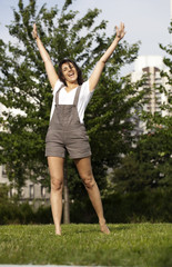 Fototapeta premium jeune femme souriante levant les mains vers le ciel