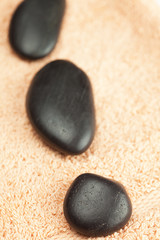 Fototapeta na wymiar a black spa stones on the towel