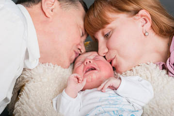 Mum and the father kiss the crying kid..