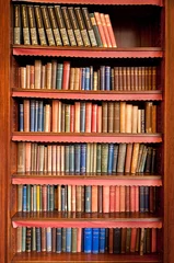 Fotobehang Bibliotheek Oude boekenplank met rijen boeken in oude bibliotheek