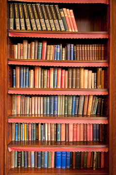 Old bookshelf with rows of books in ancient library