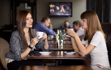 two girlfriens talking in cafe