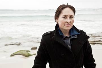 Attractive woman at beach with thoughtful expression.