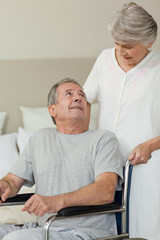 Retired man in his wheelchair with his wife