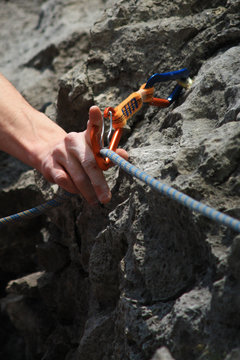 hand caring for safety with a carabiner while climbing