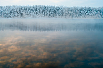 Unfrozen lake in the winter forests of Karelia, Russia.