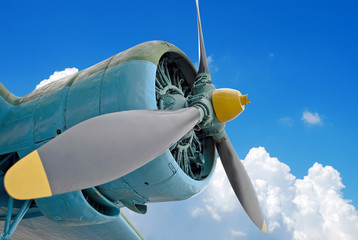 The engine of the old plane against blue cloudy sky