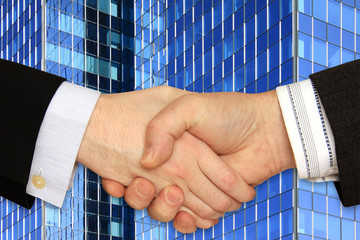 Businessmen shaking hands in front of the modern Building