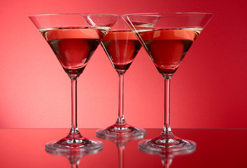 Three martini glasses on red background