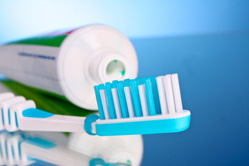 toothpaste and brush on a blue background