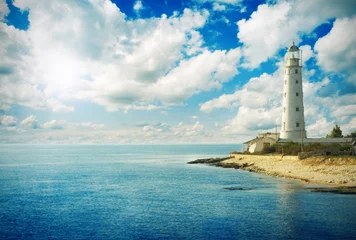 Tuinposter Old lighthouse on sea coast © Alexander Ozerov