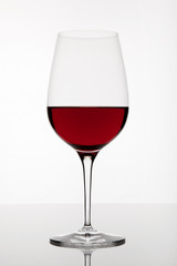 Glass of red wine on a bright background