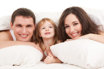 Happy family, mother, father and daughter resting on the white b