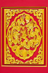 Golden dragon statue on the red wall of Chinese temple