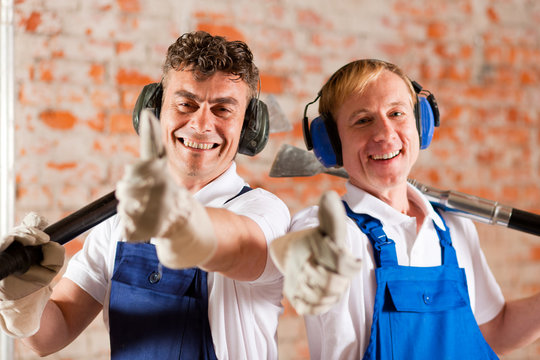 Friendly construction workers with thumps up