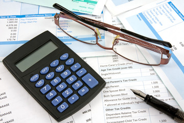 Business reports with calculator,eyeglasses and pen