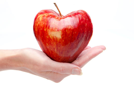 Hand with an apple in the form of heart