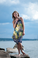 sad woman standing on rock over storm sea