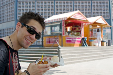 Mann isst Currywurst in Berlin