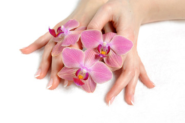 Obraz na płótnie Canvas Beautiful hand with perfect nail french manicure and purple orch