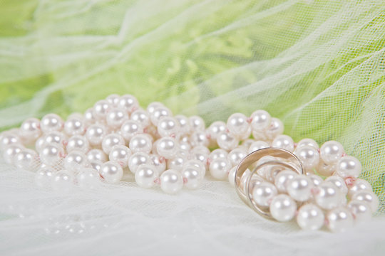 wedding rings, pearl necklaceand and bouquet of chrysanthemums