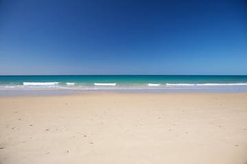white sand green ocean