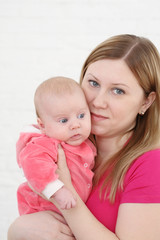 Young mum holds on hands of the chest baby