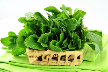 bunch of fresh green mint in a wicker basket