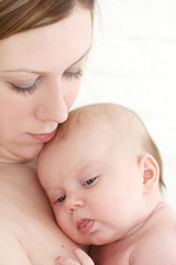 Young mum holds on hands of the chest baby