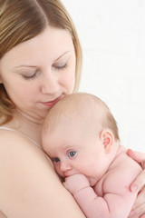 Young mum holds on hands of the chest baby