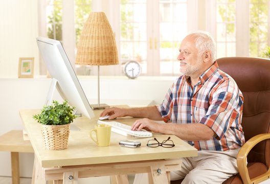 Senior man using computer at home