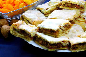 Pieces of pumpkin pie on the white plate and walnuts