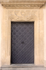 Old door with ornament in stone wall