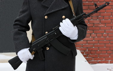 White gloves hands of a honor guard holding a Kalashnikov