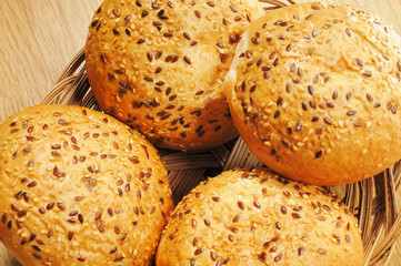 Bun, topped with sesame seeds in a basket