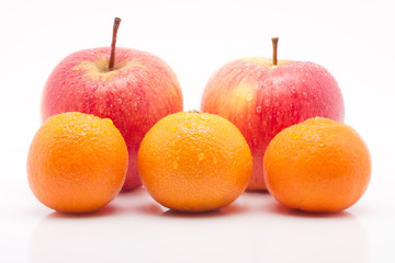 rote Äpfel und Mandarinen mit Tropfen vor weissem Hintergrund