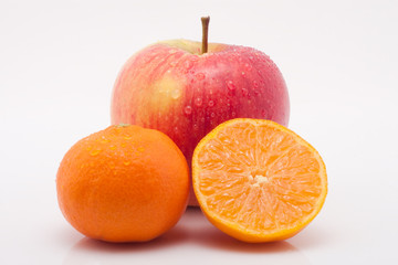 roter Apfel und Mandarinen mit Tropfen vor weissem Hintergrund