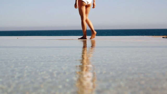 Woman walking in the water / infinity pool