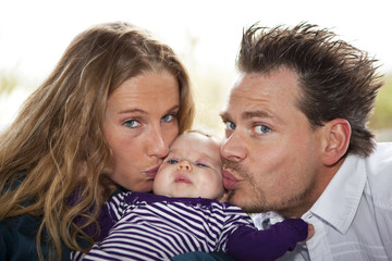 stolze Eltern küssen ihre Tochter