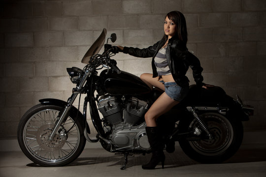 Sexy attractive twenties asian woman sitting on motorcycle