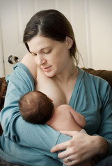 Obraz na płótnie Canvas Young mother feeding her newborn baby.